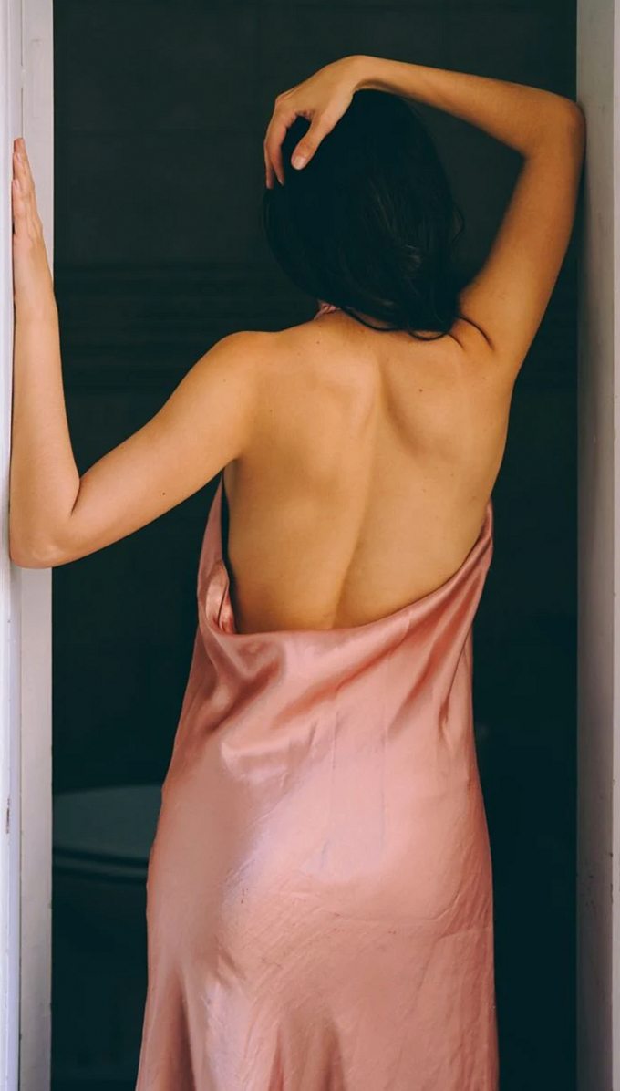 Woman seen from behind in a blush pink silk slip
